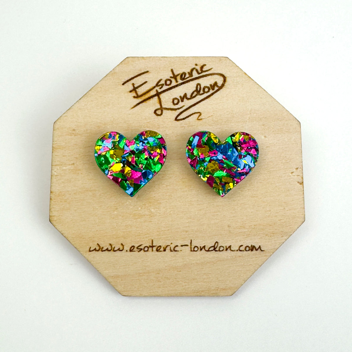 Green confetti glitter heart stud earrings with blue, pink and gold flecks on an octagonal wooden backing card