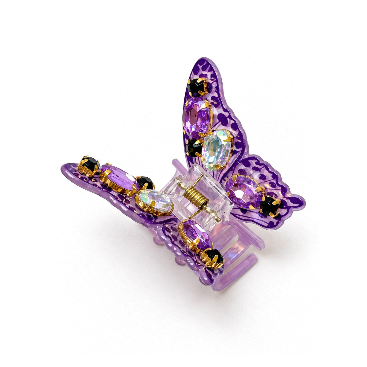 Purple butterfly claw clip at an angle, with purple and iridescent crystals and black stones in gold settings, on white