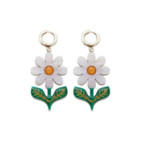 Moonlight white daisy dangle earrings with orange centres and green gold-etched leaves on a white background