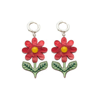 Red daisy dangle earrings with yellow centres and green leaves on silver huggie hoops, white background