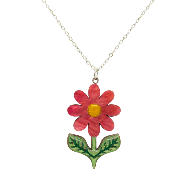 Scarlet red pearlescent acrylic daisy pendant with gold centre and green leaves, on a silver chain, on white