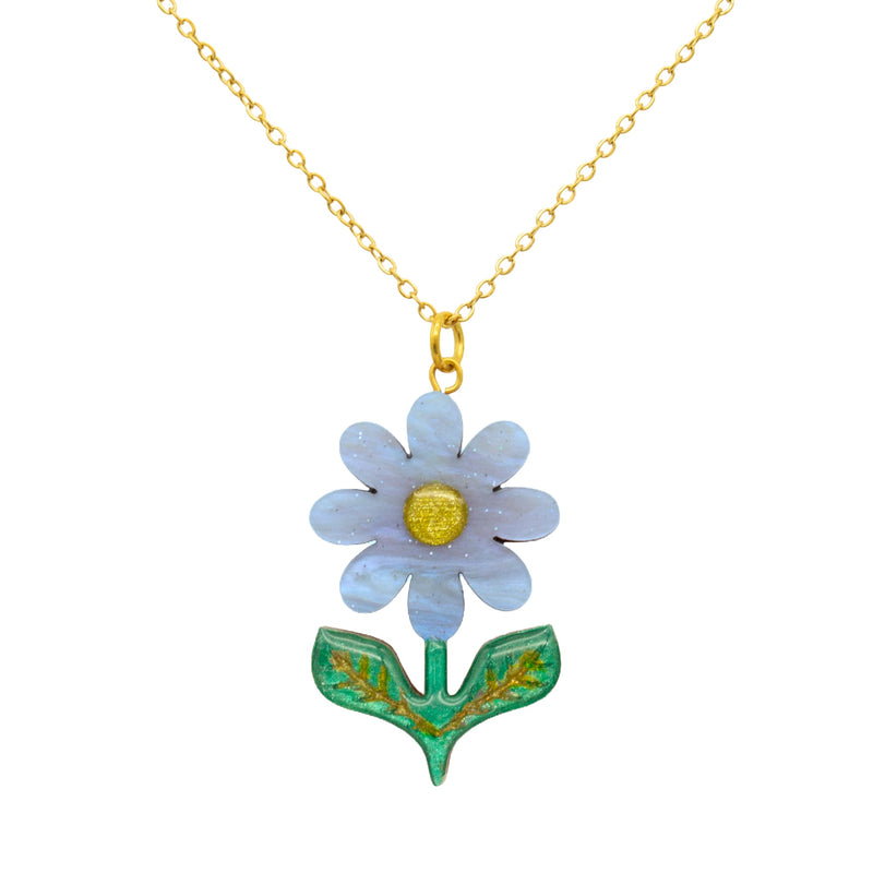 Sky blue pearlescent acrylic daisy pendant with gold glitter centre and green leaves, on a gold chain, on white
