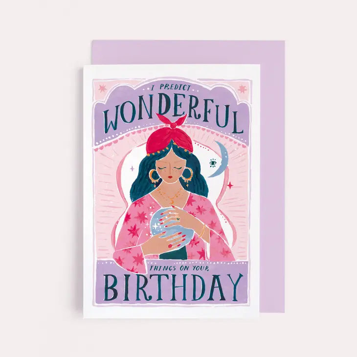 Birthday card with an illustrated fortune teller in a red headscarf holding a crystal ball, with a lilac envelope