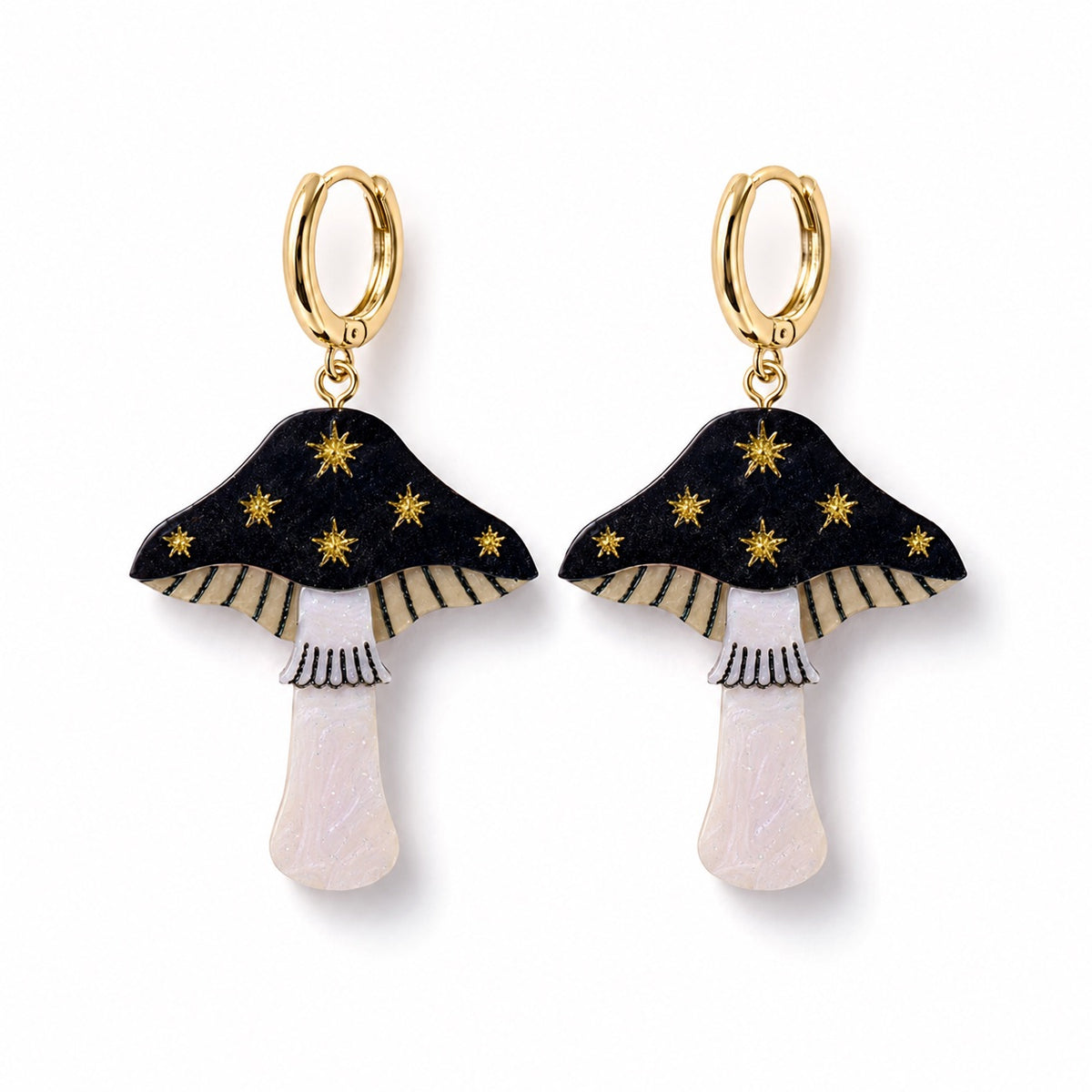 Black acrylic toadstool earrings with gold star detail, cream gills and pearly white stems on gold huggie hoops