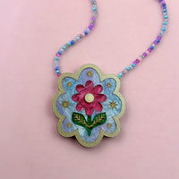 Scalloped necklace with a pink flower, green leaves and gold stars on blue acrylic, gold glitter edge, pastel bead chain